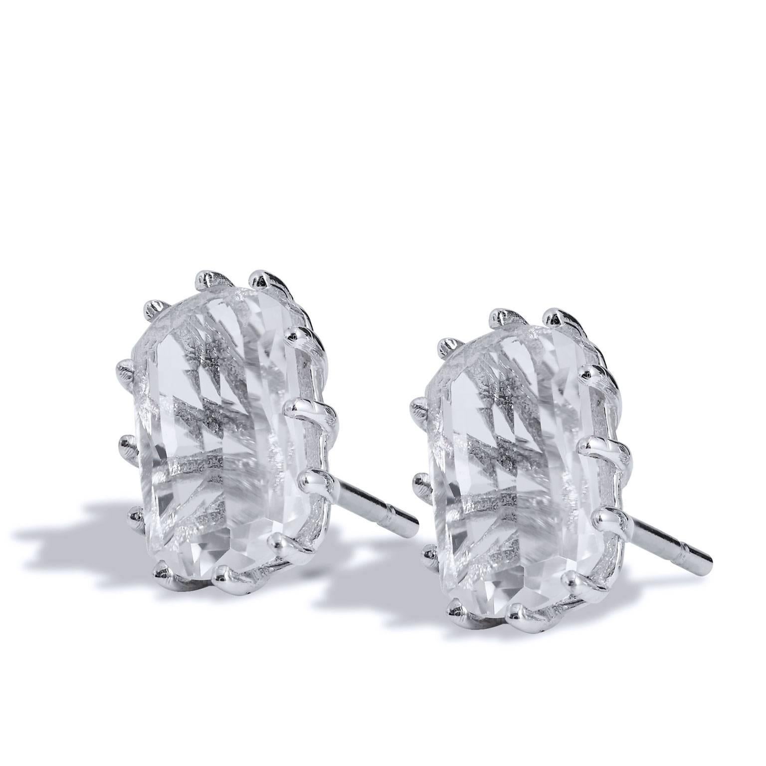 Fashioned in 14 karat white gold, these stud earrings feature two 12 millimeter by 6 millimeter barrel-shaped topaz prong-set with a stylized back.
