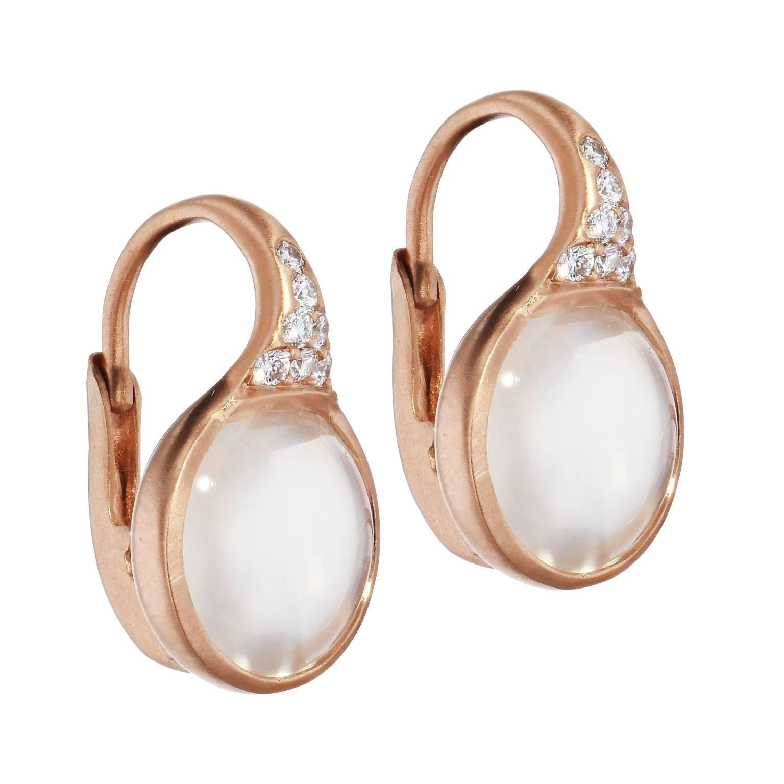 5.25 carat of cabochon white moonstone (10 millimeter) is set at center and embraced by 18 karat rose gold while 0.14 carat of pave-set diamonds (G/VS) adorn the baile in these lever-back earrings.