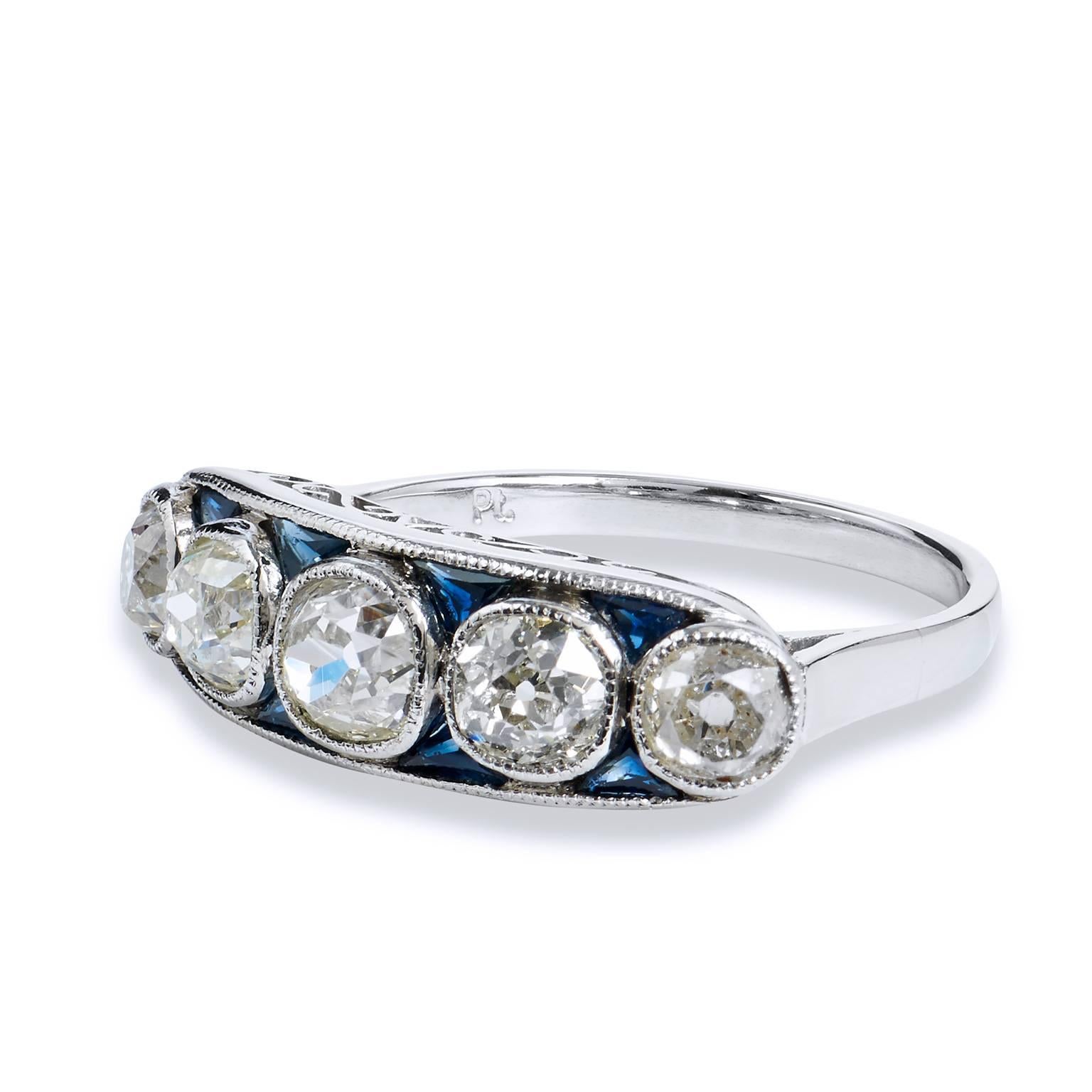 This platinum diamond band ring features 5 old mine cut diamonds, bezel set, with a total weight of 2.15 carats. The diamonds are gracefully interlaced between the sea of 8 pieces of trillion cut blue sapphires, with a total weight of 0.60 carats. 