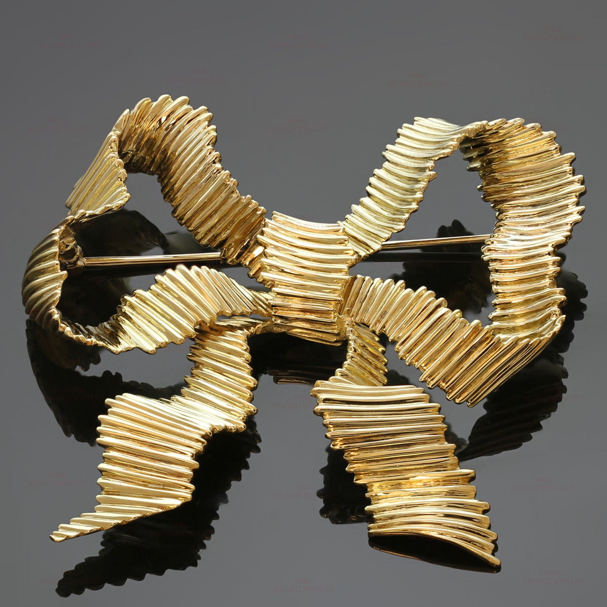 This chic Tiffany brooch features a ridged ribbon design made in solid 18k yellow gold. Measurements: 2.04