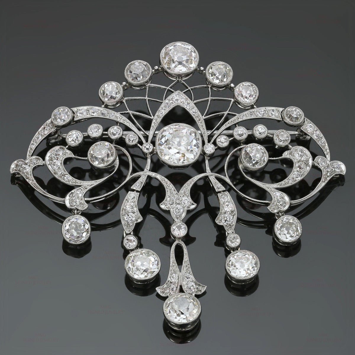 This delicate Edwardian filigree brooch is made in fine platinum and beautifully set with old mine-cut diamonds: a center H-I SI diamond of 2 carats, a top H-I VS2-SI1 diamond of 1.20 carats, a bottom H-I VS2-SI1 diamond of 1.10 carats, 2 bottom H-I