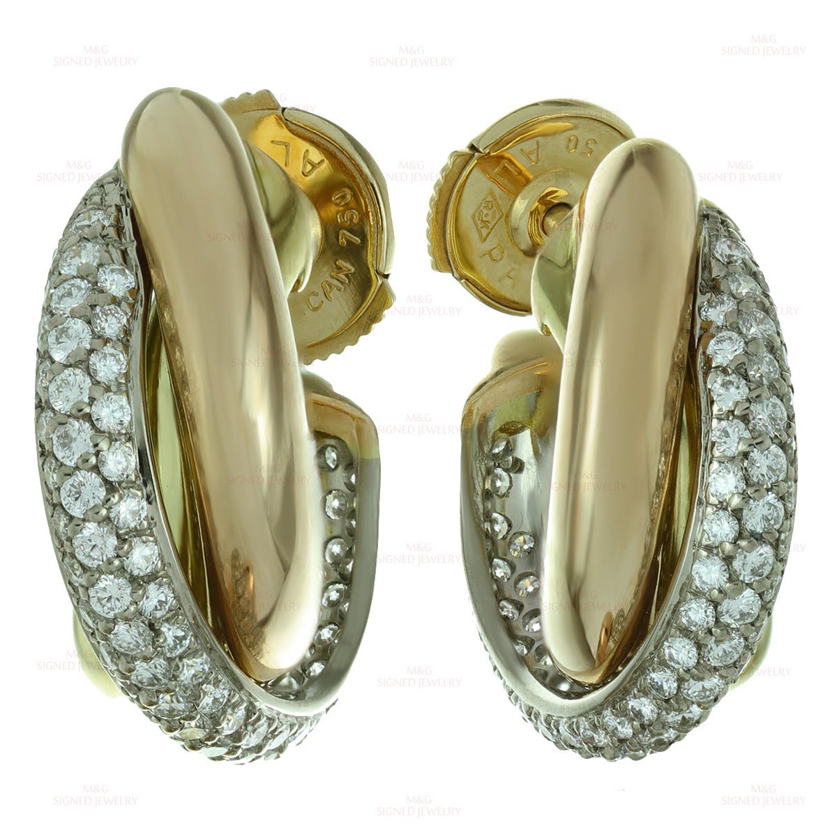 These modern wrap earrings from Cartier's classic Trinity collection feature three intertwined open hoops made in 18k yellow, white and rose gold. The white band is beautifully pave-set with round brilliant-cut E-F VVS2-VS1 diamonds of an estimated