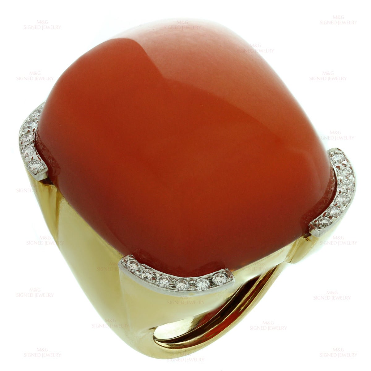 This magnificent geometric David Webb ring is crafted in 18k polished yellow gold and set with a bright reddish oval cabochon carnelian stone measuring 26.0mm x 30.0mm. Fine platinum corners are beautifully accented with round brilliant-cut G-H