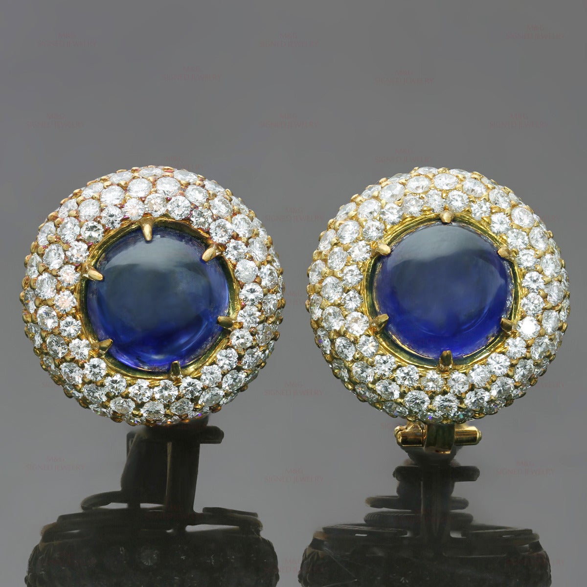 These splendid Harry Winston earrings ares made in 18k yellow gold and set with vivid blue round cabochon sapphires of an estimated 11 carats surrounded by brilliant-cut round F-G VVS2-VS1 diamonds of an estimated 5.75 carats. Made in United States