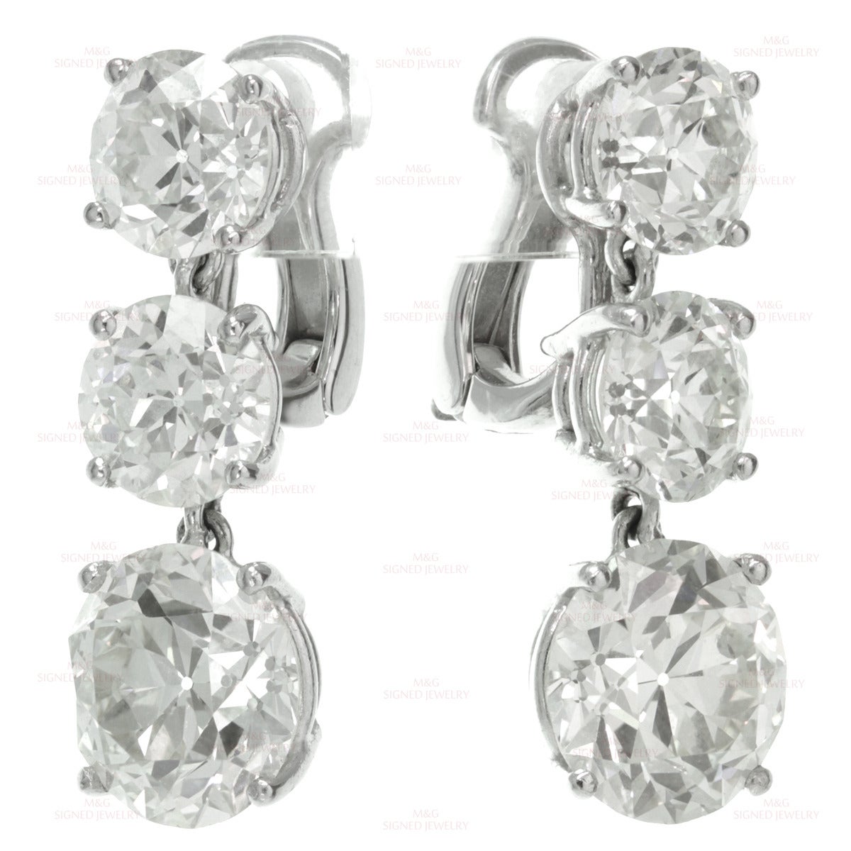 These magnificent dangling drop earrings are crafted in platinum and completed with newer 18k white gold clasps. The earrings are set with four 6.99mm to 7.23mm diamonds (3 diamonds of 1.45 carats, 1 diamond of 1.40 carats) and two 9.51mm to 9.69mm