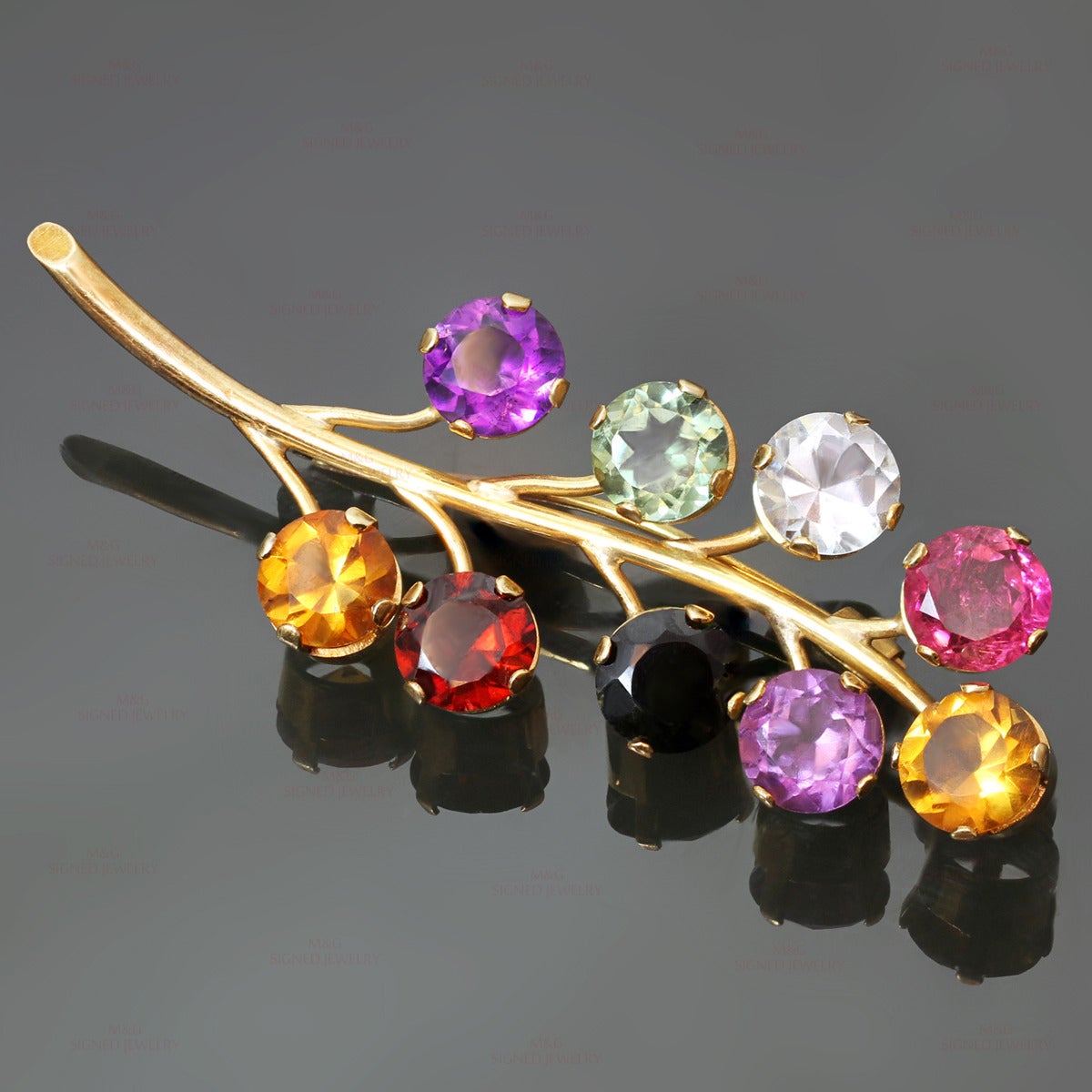 This stunning floral branch brooch is made in 18k yellow gold and prong-set with genuine faceted gemstones: amethyst, aquamarine, garnet, green tourmaline and pink tourmaline - weighing an estimated 11.5 carats. Made in United States circa 1980s.