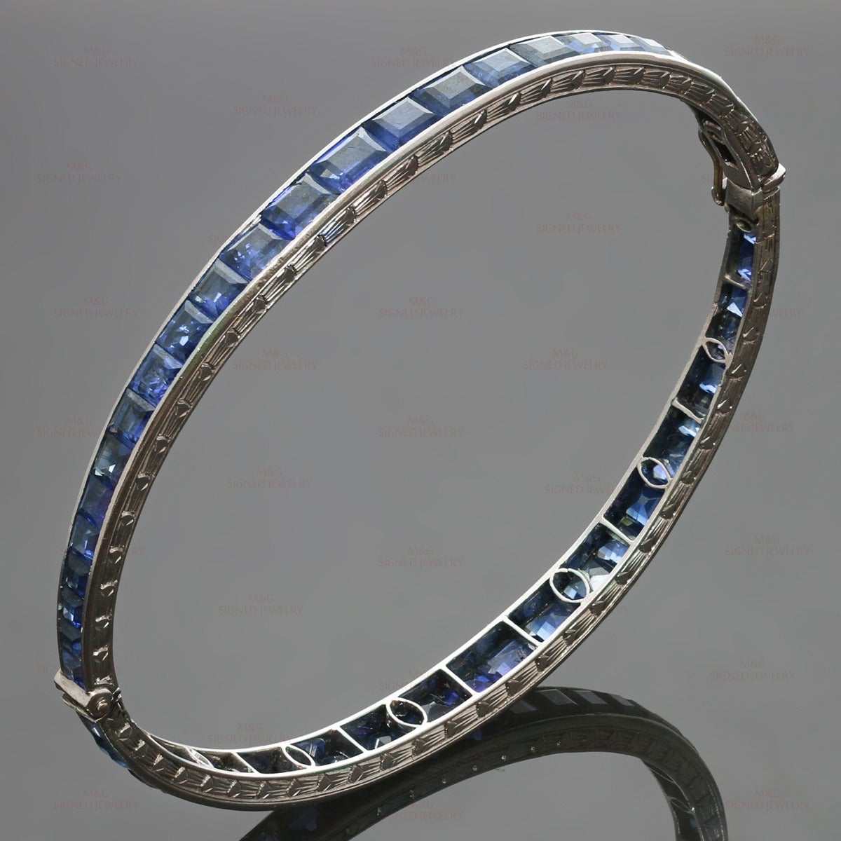 This rare and antique Van Cleef & Arpels oval bangle bracelet features a delicate hand-made filigree design crafted in platinum-iridium and set with beautifully transparent blue French-cut sapphires. Made in France circa 1930s. Measurements: 0.19