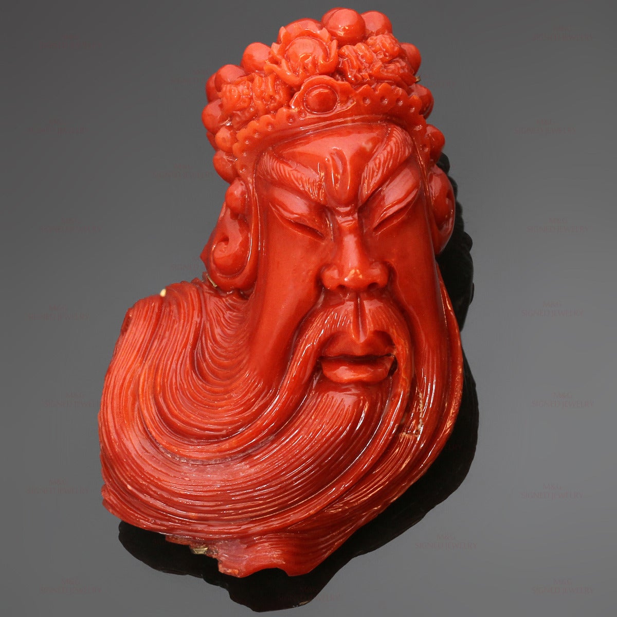 This stunning brooch/pendant features a head of an Asian bearded wise man exquisitely carved out of untreated oxblood coral and set in 18k yellow gold. Country of origin and period is unknown. Measurements: 3.0