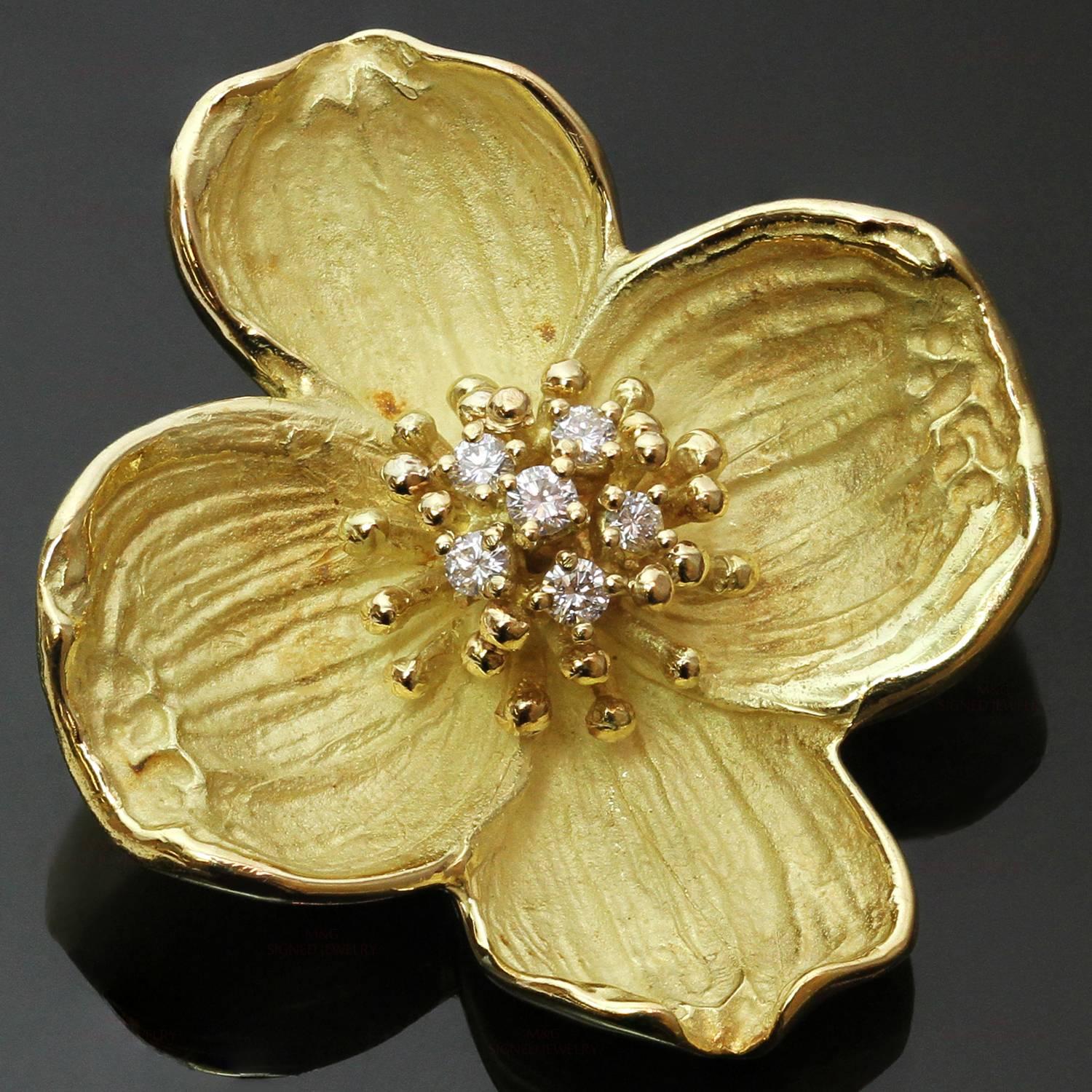 This classic Tiffany brooch features a delicate dogwood flower design crafted in 18k yellow gold and accented with brilliant-cut round diamonds of an estmated 0.20 carats. Made in United States circa 1980s. Measurements: 1.25