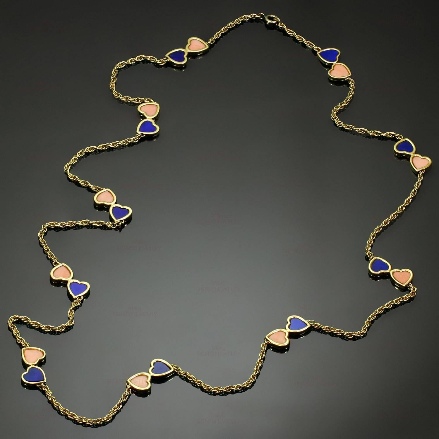 This rare and fabulous Van Cleef & Arpels necklace is crafted in 18k yellow gold and accented with romantic double-heart motifs set with pink coral and lapis lazuli. Made in France circa 1960s. Measurements: 0.38" (10mm) width, 30"