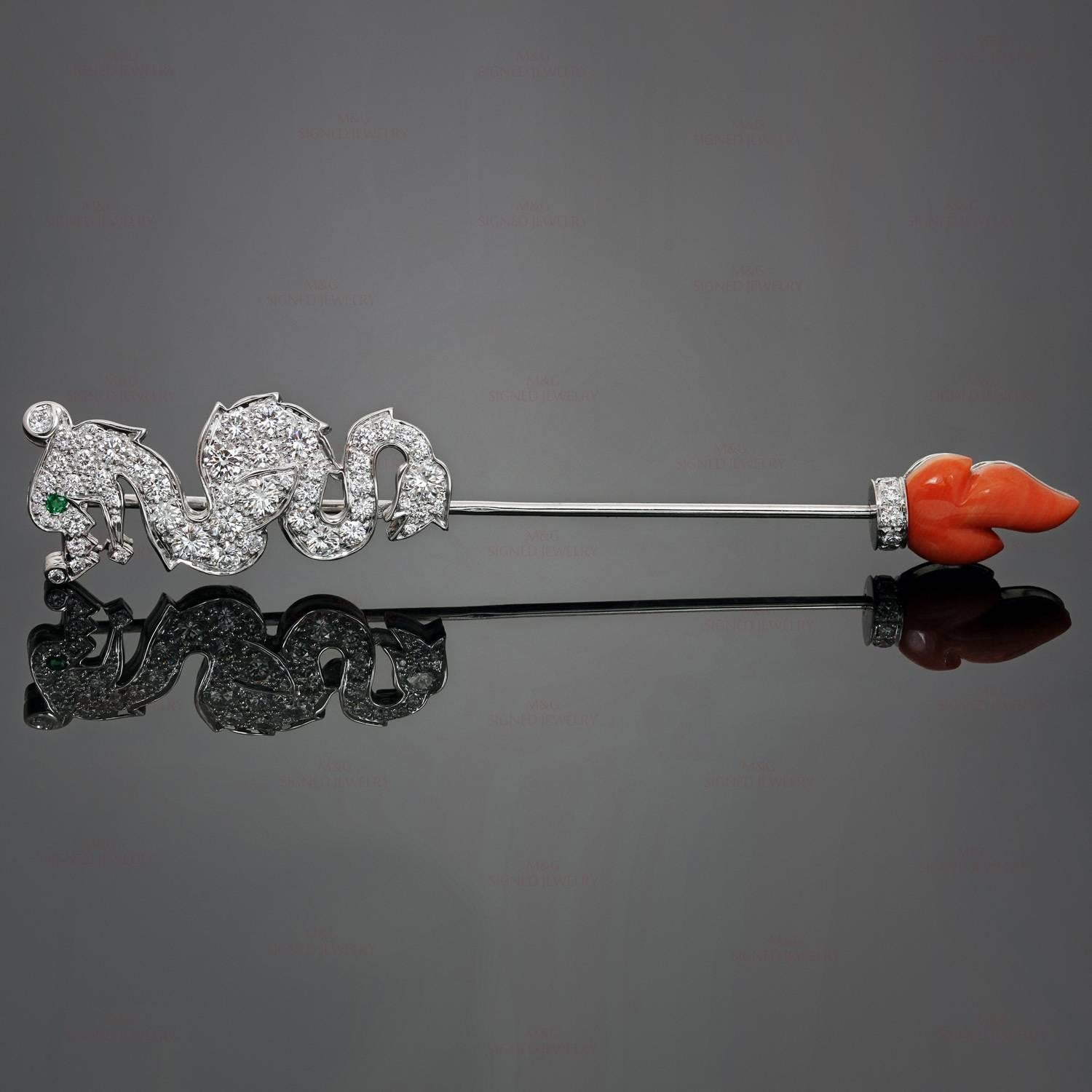This stunning Cartier jabot pin features the shape of a dragon crafted in 18k white gold and set with brilliant-cut round diamonds of an estimated 1.75 carats, accented with a faceted emerald eye and a coral flame. Made in France circa 2001.