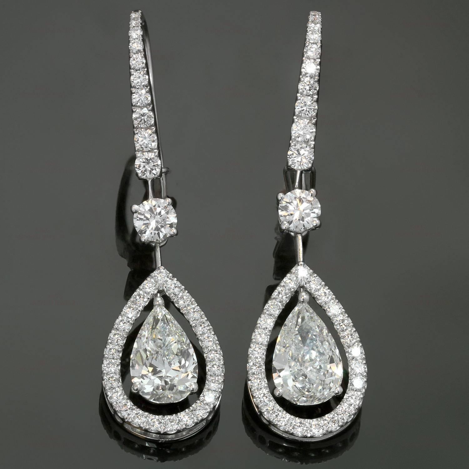 These exquisite drop earrings by Graff are crafted in 18k white gold and set with 2 GIA certified pear-shaped G VS2 diamonds weighing 3.02 carats, 2 round brilliant-cut diamonds of an estimated 0.40 carats and 60 smaller diamonds of an estimated