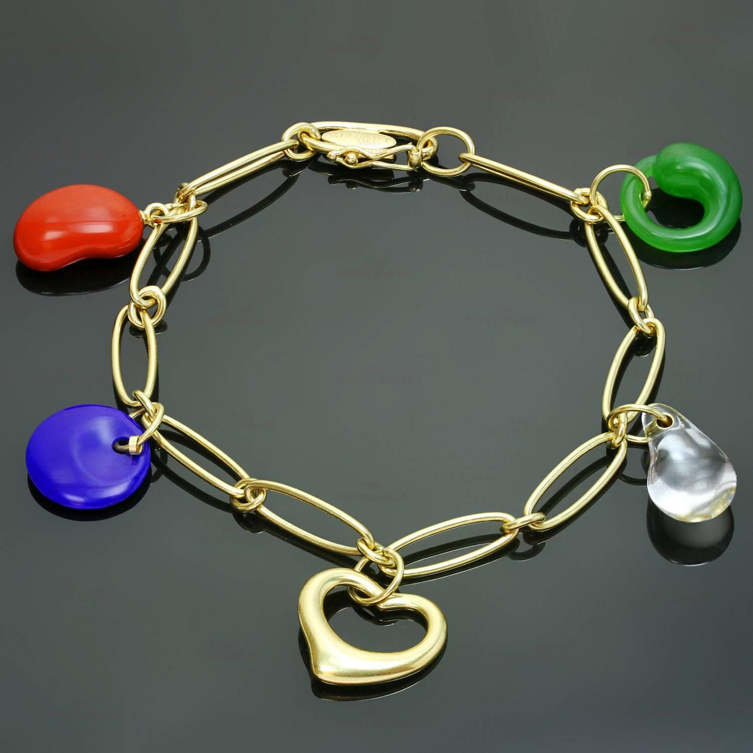 This vibrant Tiffany bracelet from the Cat Island Beach Shell designed by Elsa Peretti is crafted in 18k yellow gold bracelet and accented with green jade, blue lapis, red jasper, crystal, and a heart-shaped charm. The vibrant charms resemble the