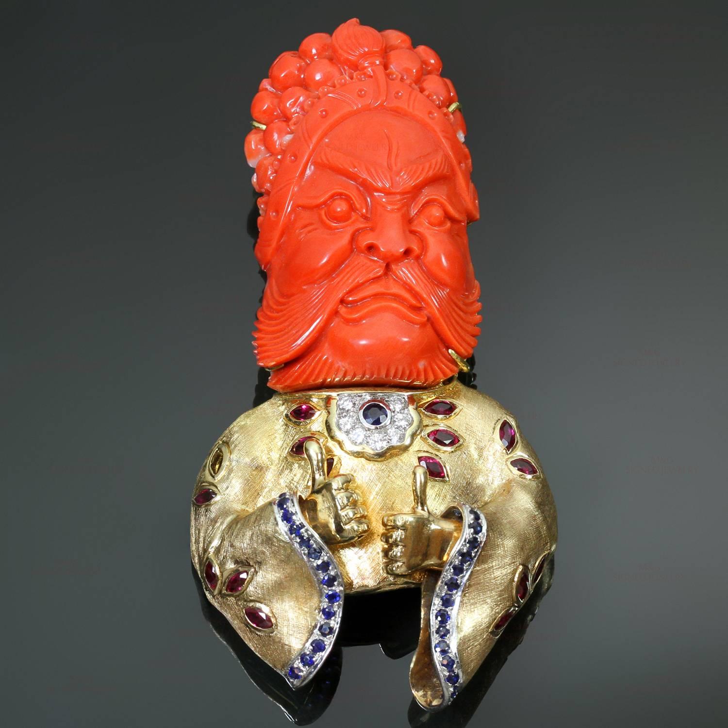Diese seltene, handgefertigte Brosche zeigt eine Kamee aus roter Koralle, die einen Lu, den chinesischen Gott des Reichtums, darstellt. Die Brosche ist aus 18 Karat Gelbgold gefertigt und  akzentuiert mit Rubinen im Marquiseschliff mit einem