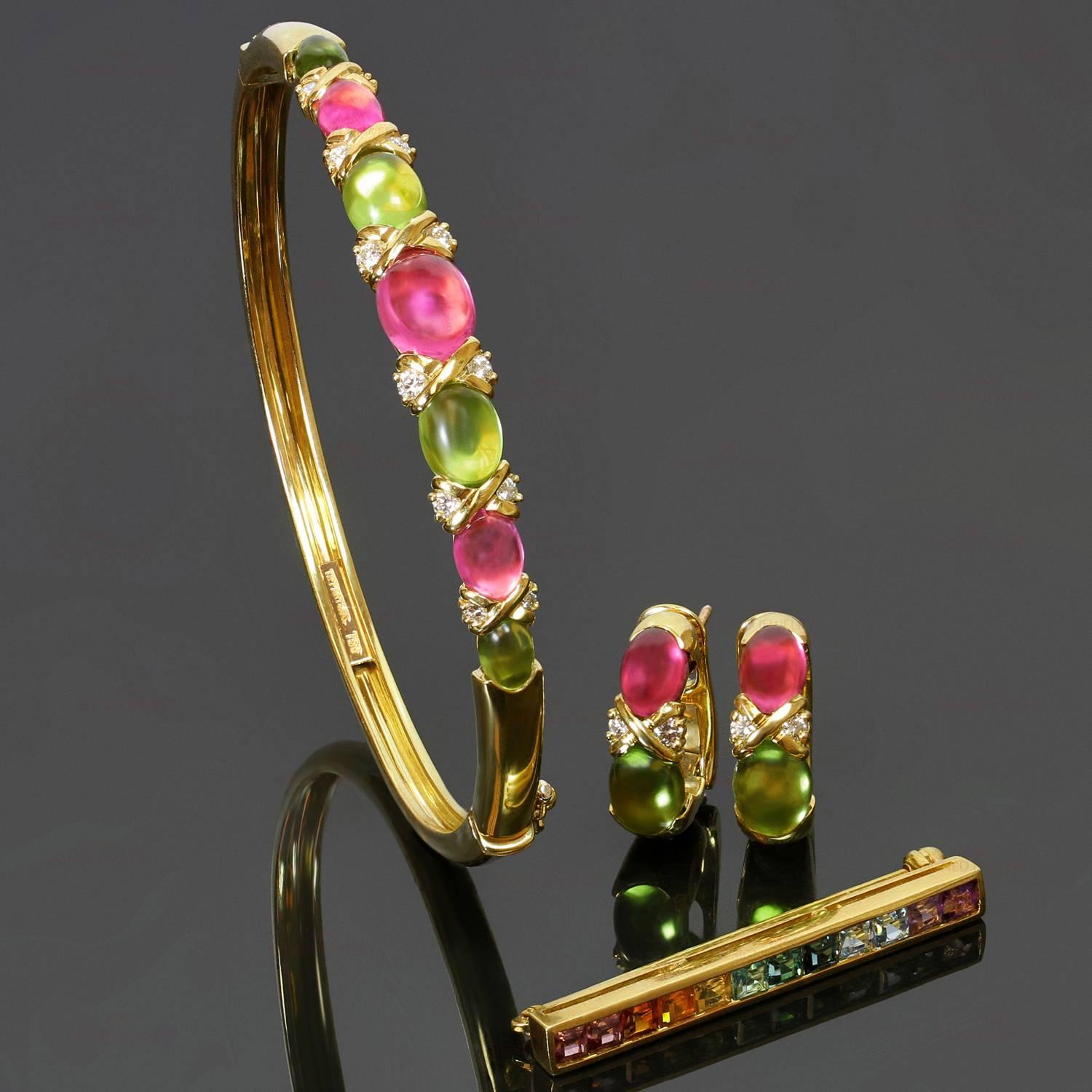 This gorgeous Tiffany jewelry set consists of a bangle bracelet, lever-back earrings, and a bar brooch. The bracelet and earrings are set with cabochon oval pink tourmaline and peridot stones and accented with full-cut diamonds weighing an estimated