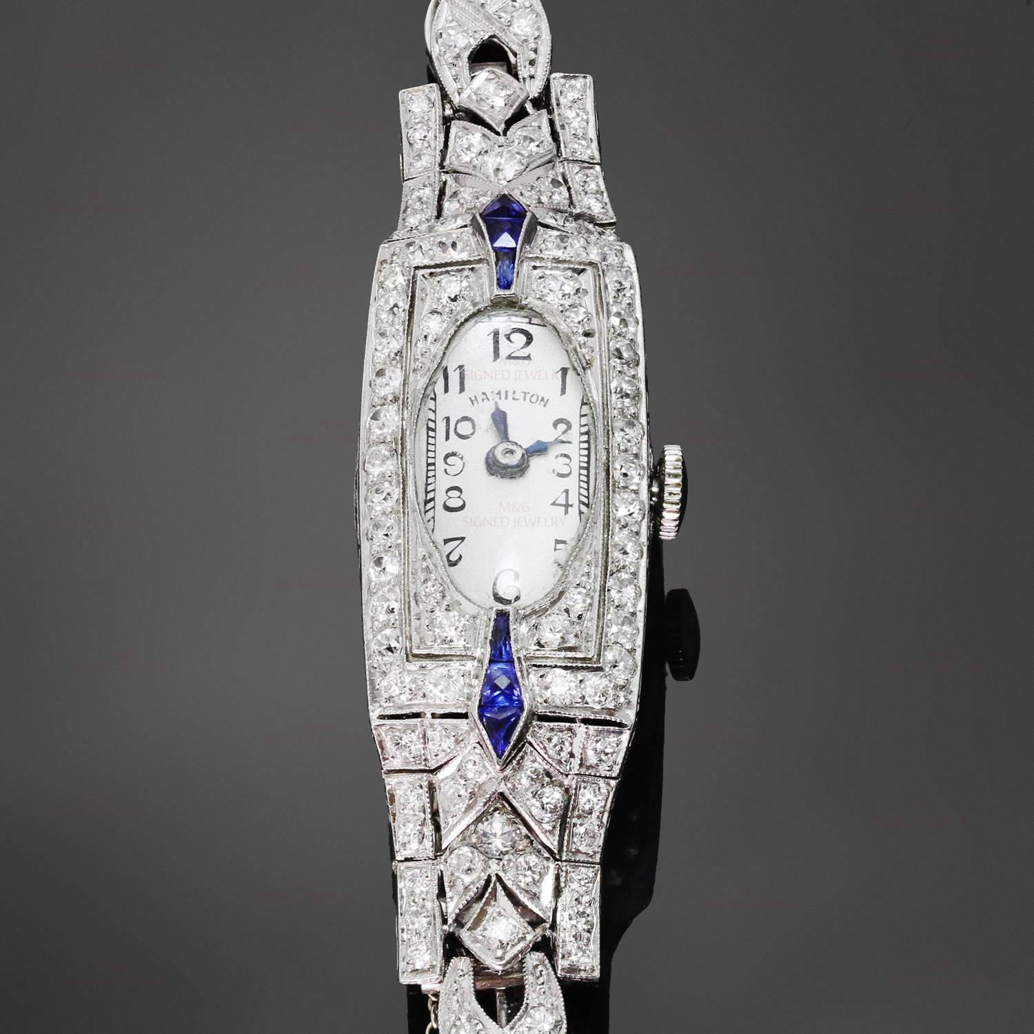 This stunning antique Hamilton manual wind watch is crafted in platinum and set with blue sapphires and 127 French-cut diamonds of an estimated 2.95 carats. The oval face displays the maker's mark Hamilton and is fitted with shaped blue hands. Made