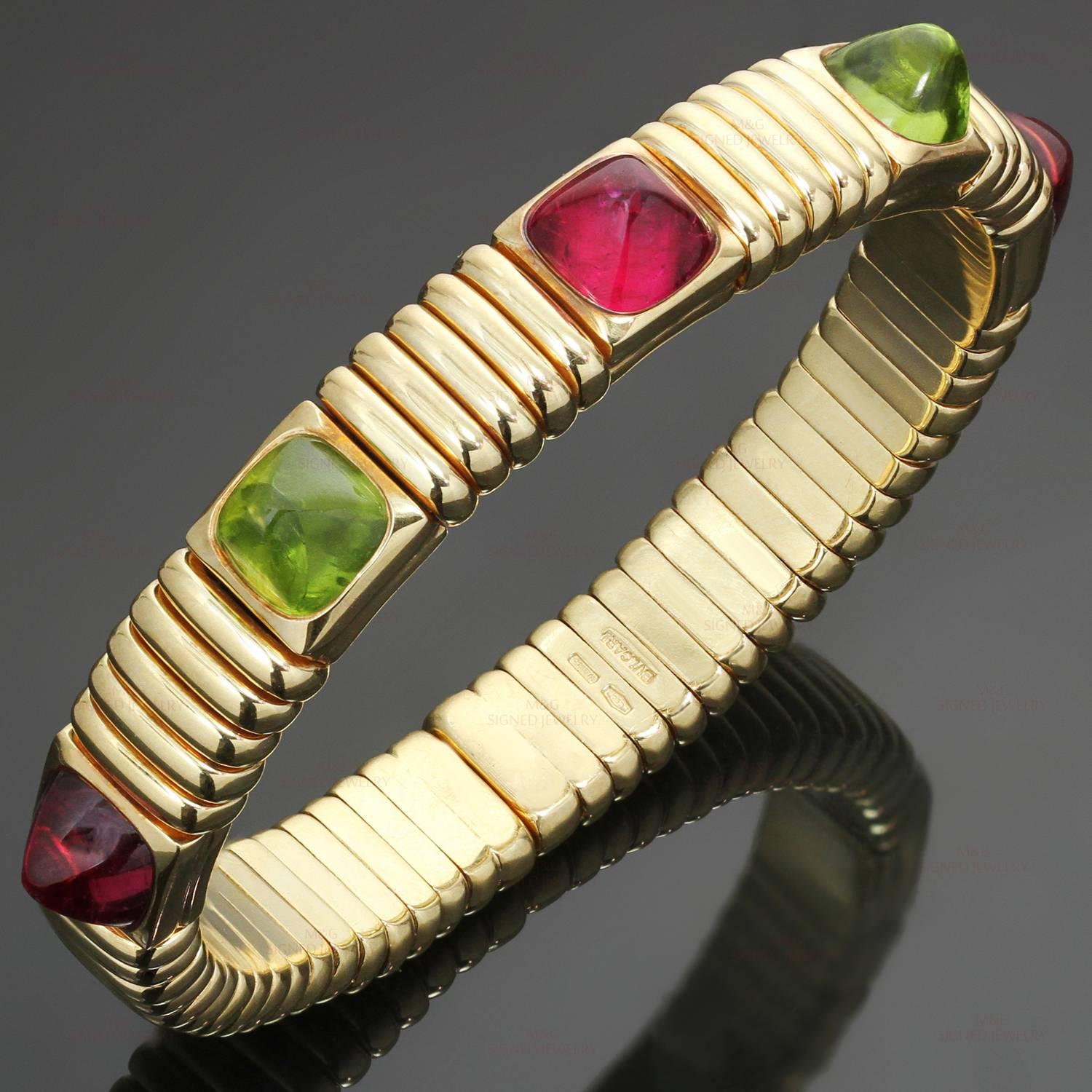 This gorgeous spring cuff bracelet from Bulgari's iconic Tubogas collection features sugarloaf cabochon gemstones - 2 peridots and 3 rubellites, set in 18k yellow gold. Made in Italy circa 1990s. Measurements: 0.38" (10mm) width, 7"
