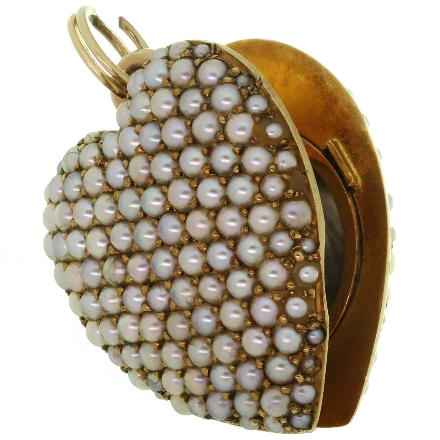 This wonderful 14 karat dimensional puffed heart shaped locket is not your ordinary locket as both sides are fully covered with beautiful individually bead-set little pave-set split seed pearls. The pearls are lustrous and the color is a mellow