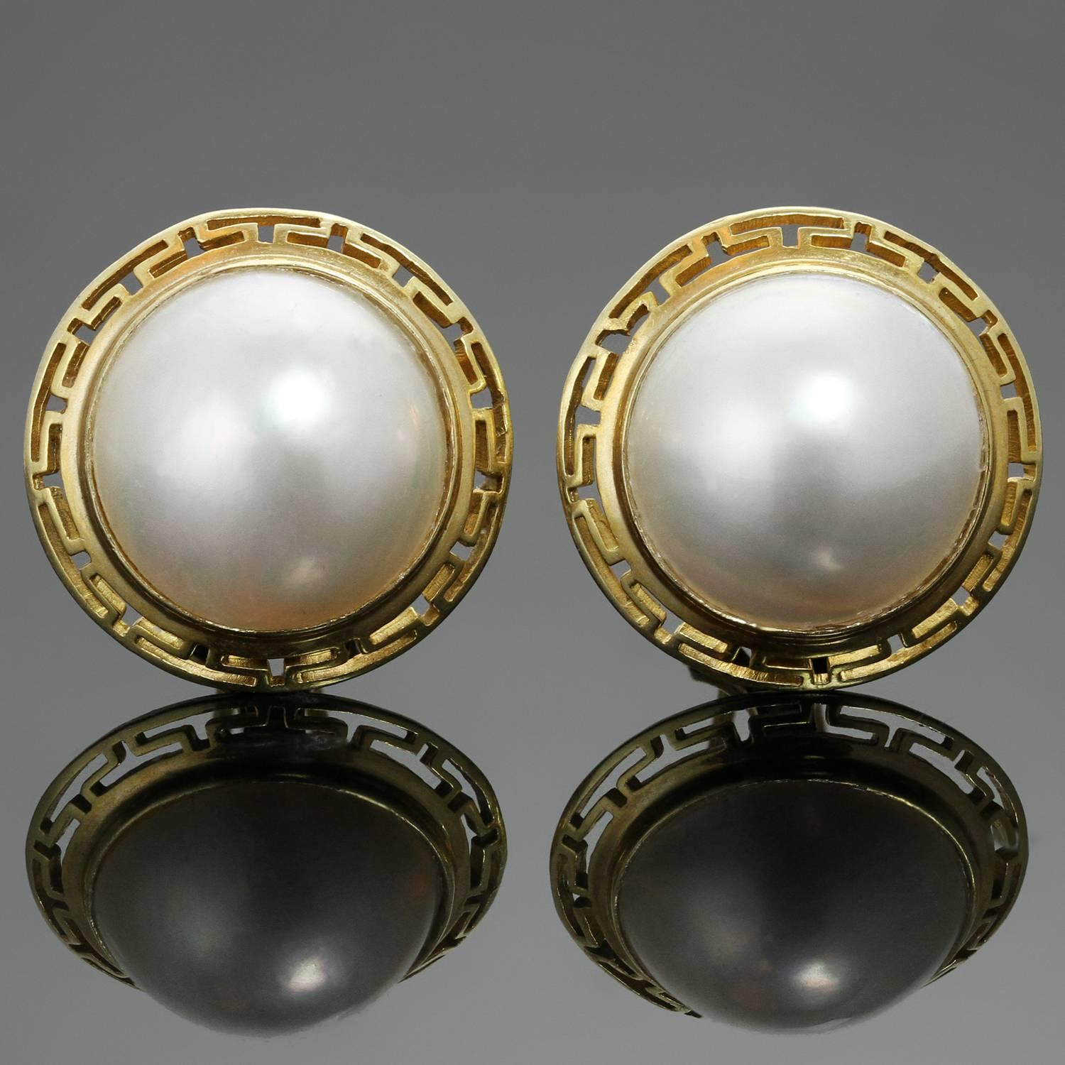These timeless 18k yellow gold round lever-back earrings are set with 14.0mm mother-of-pearls and feature a greek key pattern border. Made in United States circa 1990s. Measurements: 0.78
