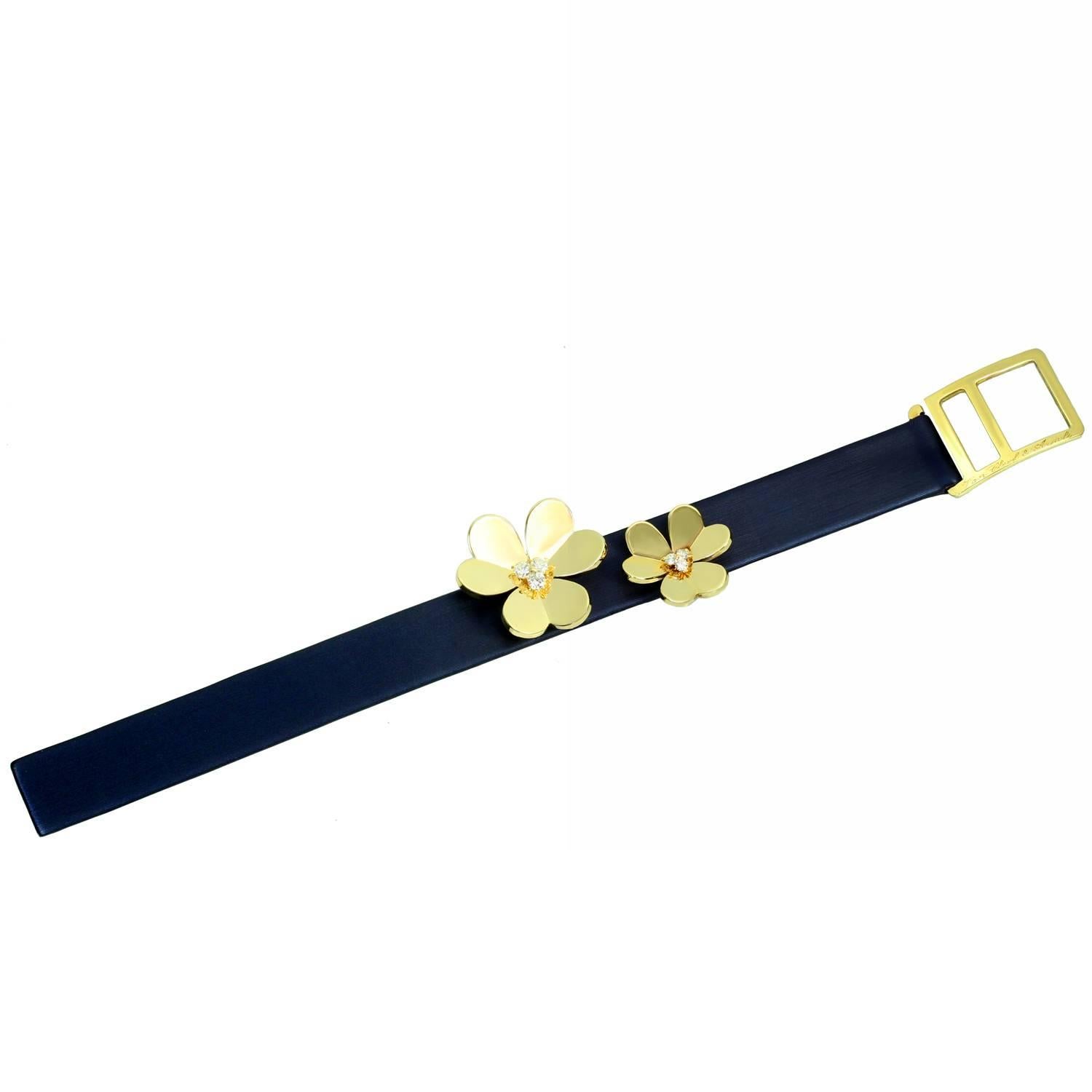 This fabulous Van Cleef & Arpels bracelet from the iconic Frivole collection features a navy blue satin on leather strap beautifully mounted with a pair graduated 18k yellow gold flowers prong-set with brilliant-cut round D-F VVS1-VVS2 diamonds of