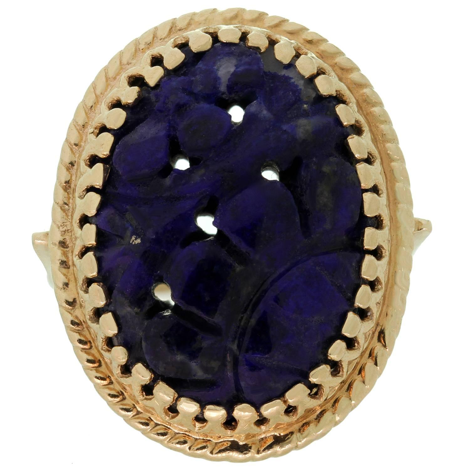 This fabulous vintage cocktail ring is crafted in 14k yellow gold and set with a beautifully hand-carved oval natural lapis lazuli stone. Made in United States circa 1970s. Measurements: 0.74