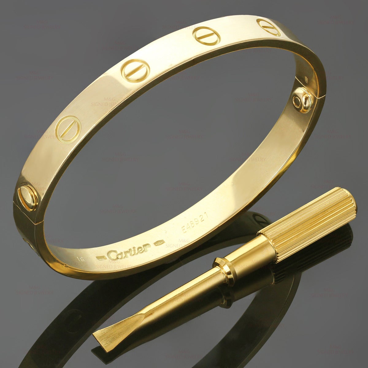 This iconic and timeless bracelet from Cartier's Love collection is finely crafted in 18k yellow gold and completed with the original Cartier screwdriver. This bangle is a size 16. Made in France. Measurements: 0.23