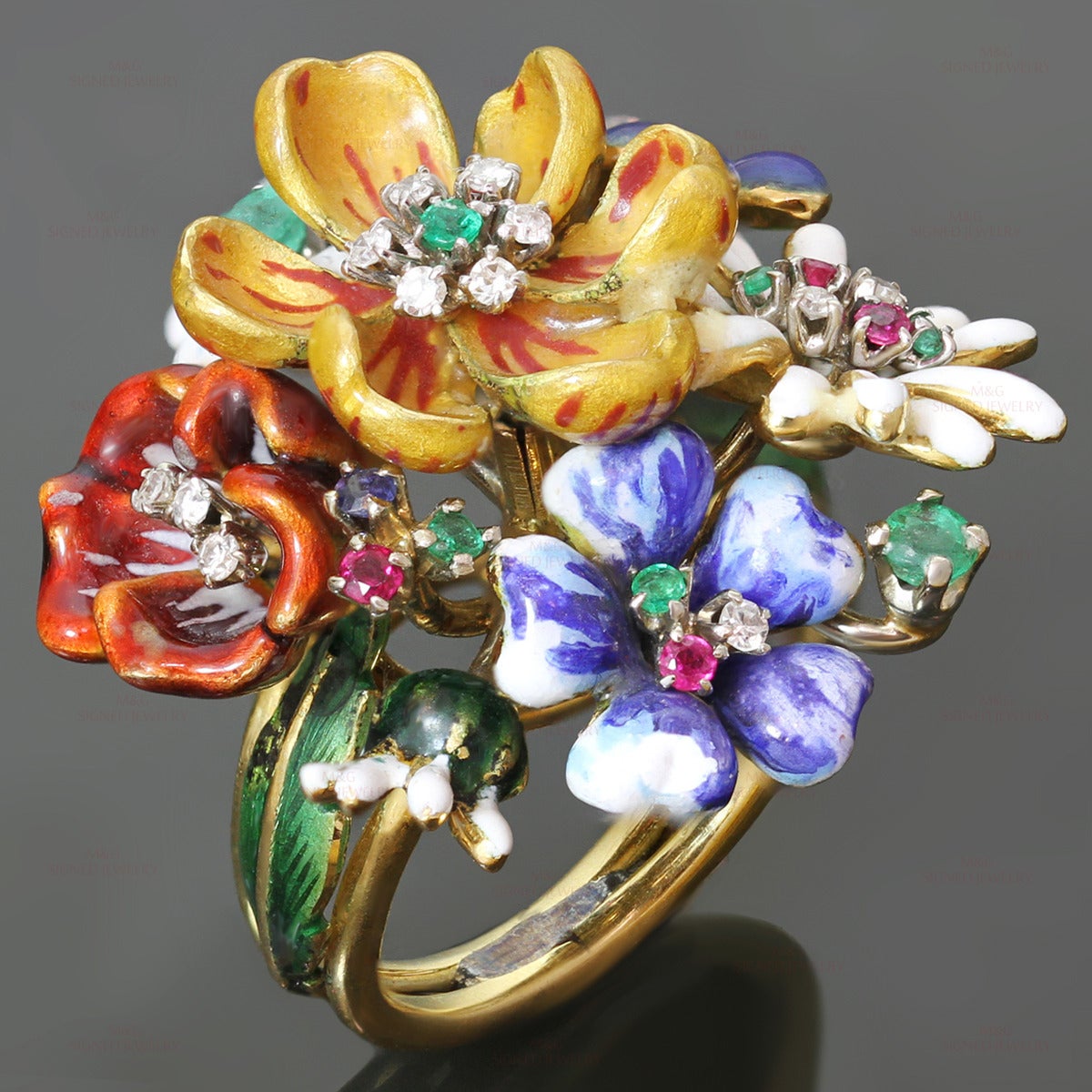 This exquisite hand-crafted ring features a colorful enamel bouquet of wild flowers, made in 18k yellow gold and prong-set with sparkling diamonds, rubies, and emeralds. The H-I VS2-SI1 diamonds weigh an estimated 0.30 carats and the faceted