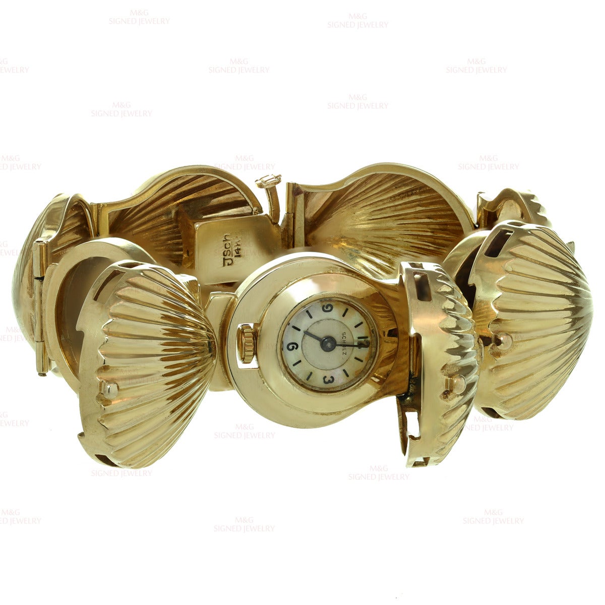 This elegant watch bracelet features seashell links made in 14k yellow gold and completed with 2 hidden side lockets and 1 center locket containing a timepiece. The center locket is set with brilliant-cut round H-I VS1-VS2 diamonds of an estimated