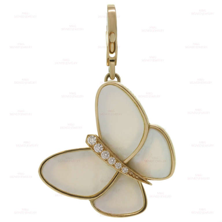 This graceful butterfly charm pendant is a classic Van Cleef & Arpels motif with natural mother of pearl wings inlaid in 18k yellow gold and accented with 6 round brilliant-cut F-G VVS2-VS1 diamonds of an estimated 0.16 carats. Estimated Retail