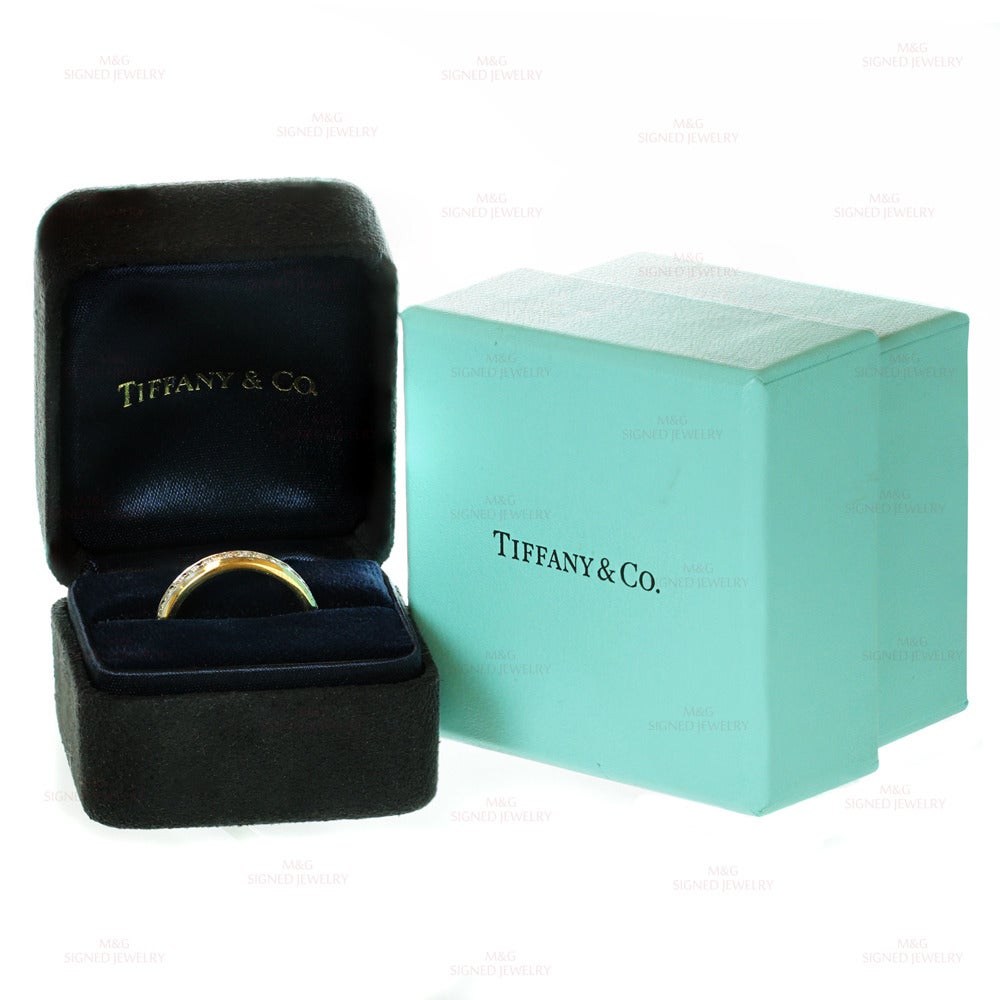 This elegant band ring from Tiffany's classic Lucida collection is crafted in 18k yellow gold and set with special-cut E-F VVS1-VVS2 diamonds of an estimated 2.35 carats in fine platinum. Measurements: 0.15