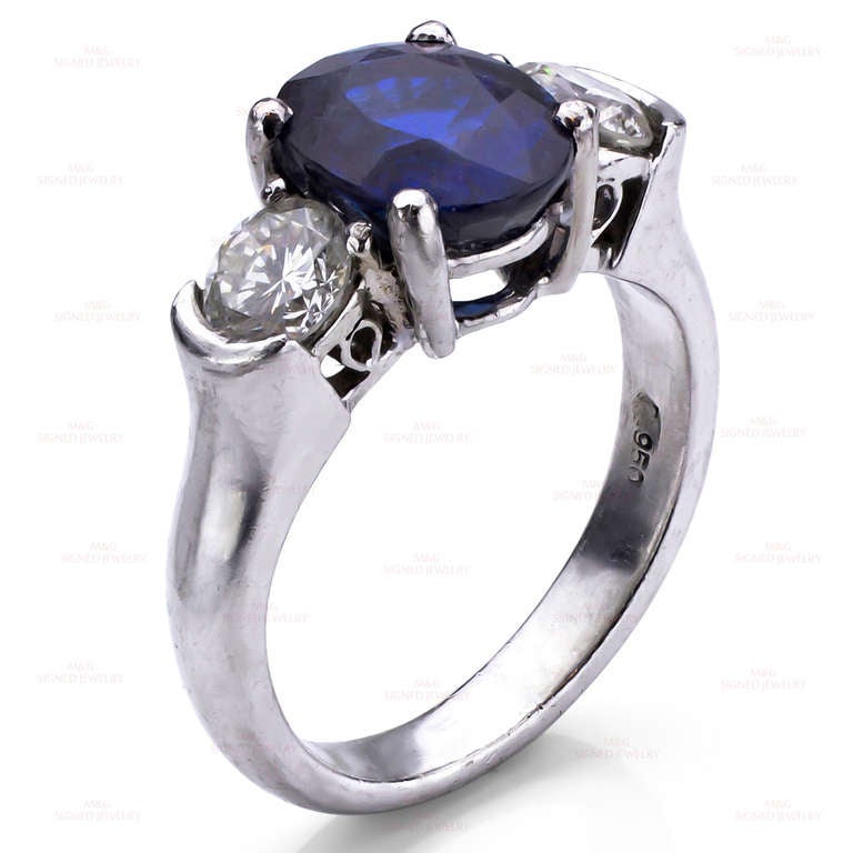 An elegant estate ring made in platinum and set with a natural 2.79 carat faceted oval blue sapphire measuring 9mm x 7mm x 5mm. The sides are completed by 2 sparkling diamond of an estimated 0.60 carats. Diamond color is H-I, Diamond clarity is