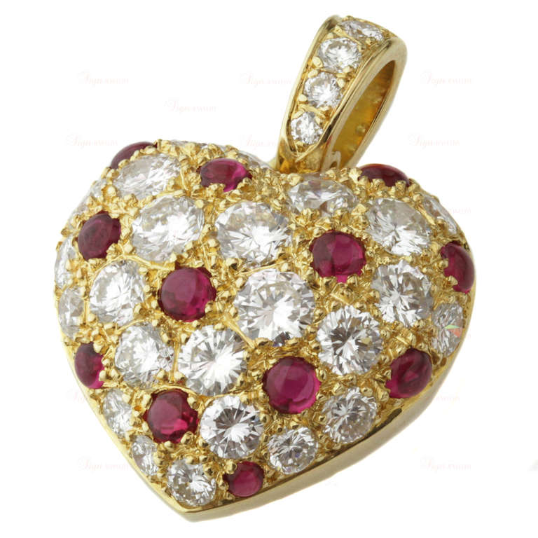 A charming yellow gold pendant from Cartier featuring a 16.0mm heart set with 12 cabochon rubies of an estimated 0.80 carats and sparkling round F-G VVS2-VS1 diamonds of an estimated 1.5 carats. Circa 1990s. An elegant and romantic design.