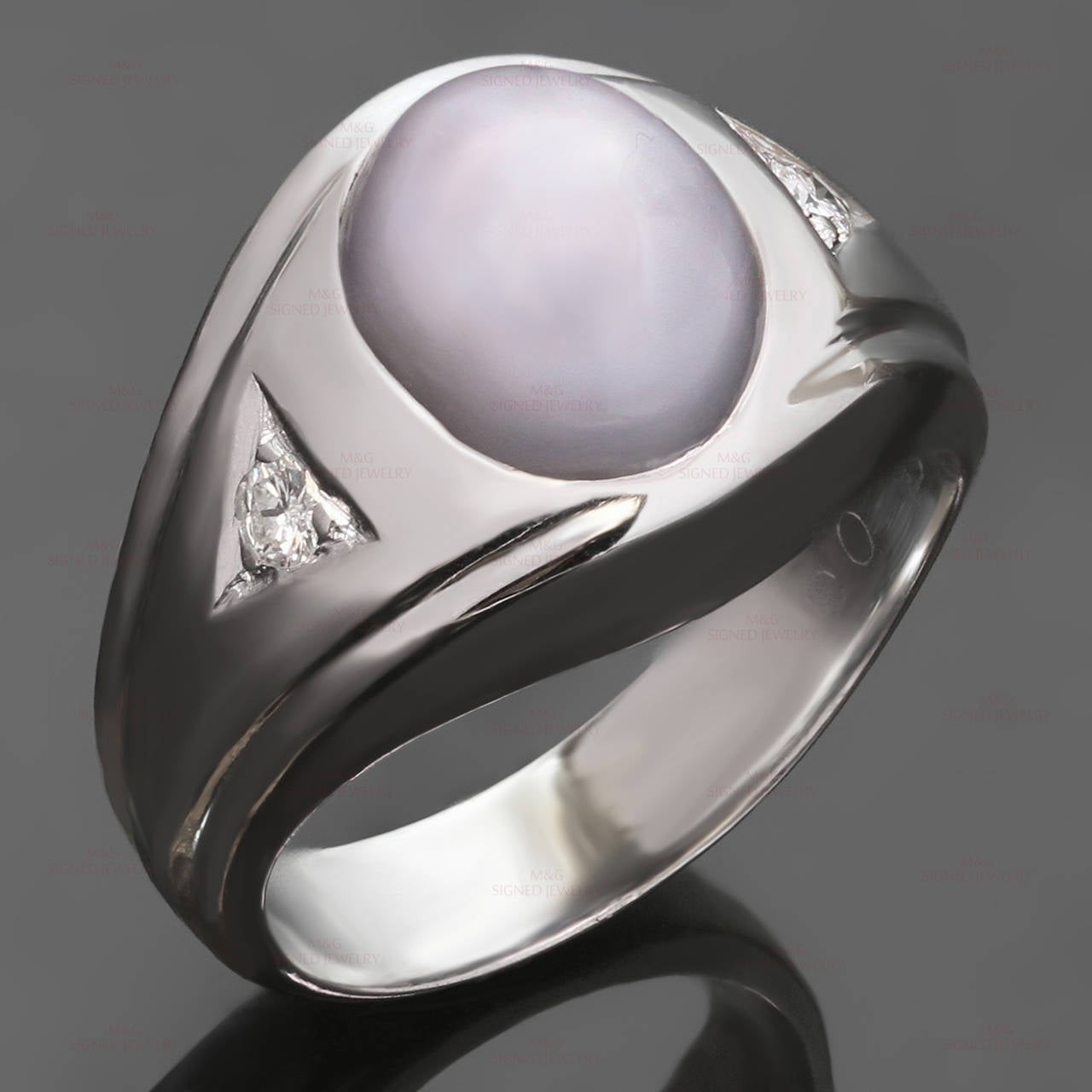 This classic ring is crafted in 14k white gold and set with an oval 8.0mm x 10.0mm x 7.6mm grayish-purplish star sapphire approximate 6.5ct - 7.0ct. accented on sides with brilliant-cut round H-I VS1-VS2 diamonds of an estimated 0.12 carats. Made in