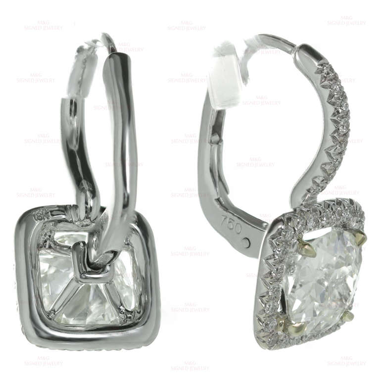 These stunning modern square drop earrings are made in 18k white gold and prong-set with 2 sparkling cushion-cut K-L VS diamonds of an estimated 2.33 carats, surrounded by 64 diamonds of an estimated 0.50 carats. Measurements: 0.38