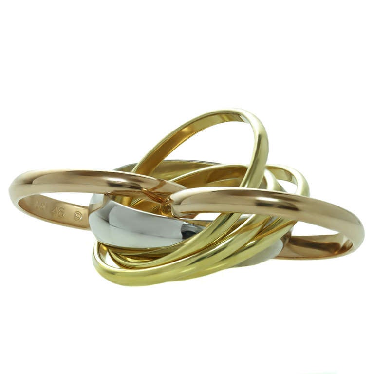 This fabulous La Belle ring from Cartier's iconic Trinity collection is made in 18k yellow gold and features 6 intertwined bands - three 2.6mm yellow gold bands, two 2.6mm rose gold bands, and one 5.2mm white gold band set with a brilliant-cut round