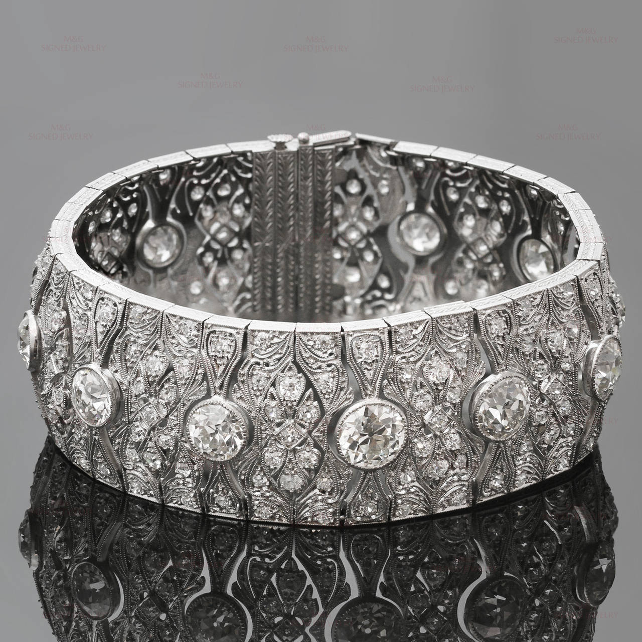 This stunning antique 1920s bracelet features an elegant filigree design hand-crafted in platinum and set with 12 large old-mine diamonds of mostly VS and some SI1 clarity weighing an estimated 16.50 carats and 204 small round diamonds of mostly