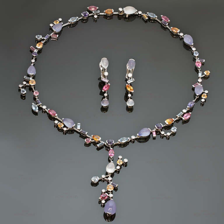 This magnificent asymmetrical drop necklace and earrings suite from Cartier's Meli Melo collection is made in fine platinum and set with a stunningly colorful array of multi-shaped gemstones - blue chalcedony, moonstone, aquamarine, garnet, pink