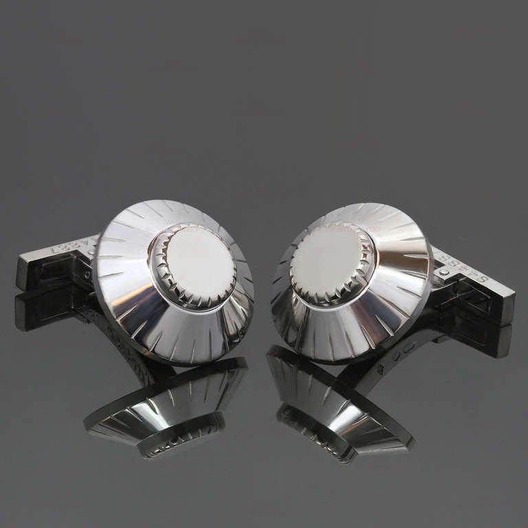 These modern Cartier cufflinks made in 18k white gold and featuring circular panels modeled as safe combination locks with twisting central station to opposing hinged bar terminals. A fabulous design unique to Cartier. Measurements: 0.66