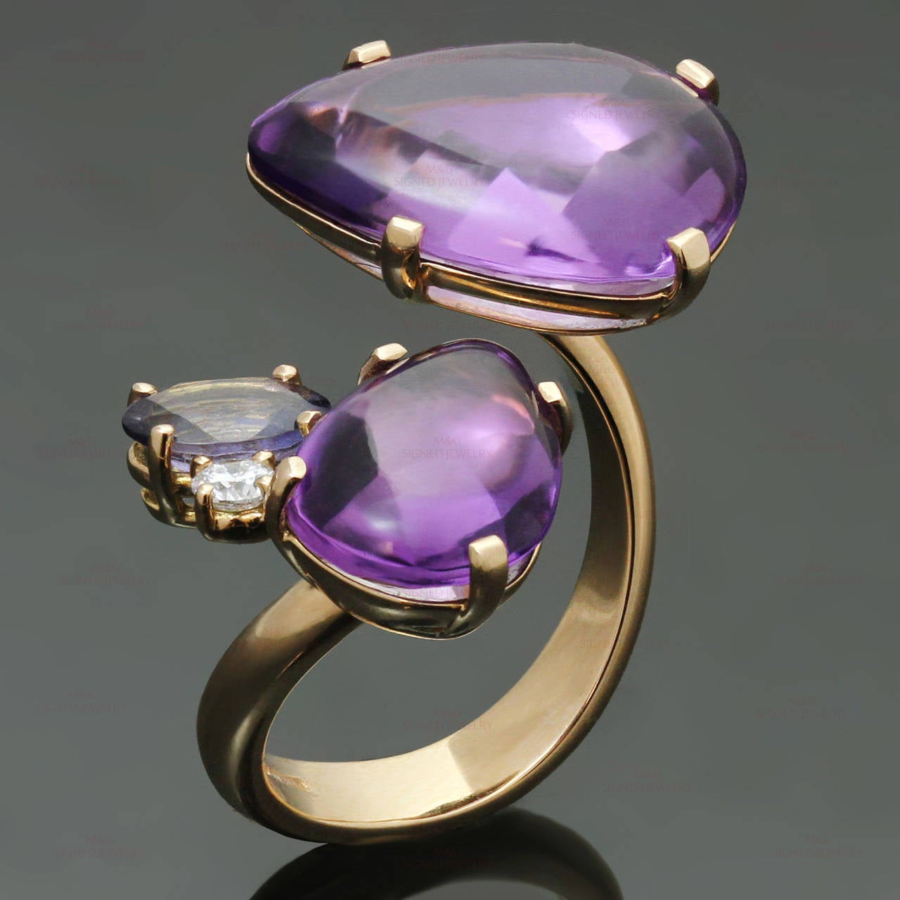 This elegant Antonini ring is crafted in 18k yellow gold and beautifully set with cabochon amethyst stones, a faceted iolite and a sparkling round brilliant-cut diamond. Made in Italy circa 2000s. Measurements: 0.66" (17mm) width. The ring size