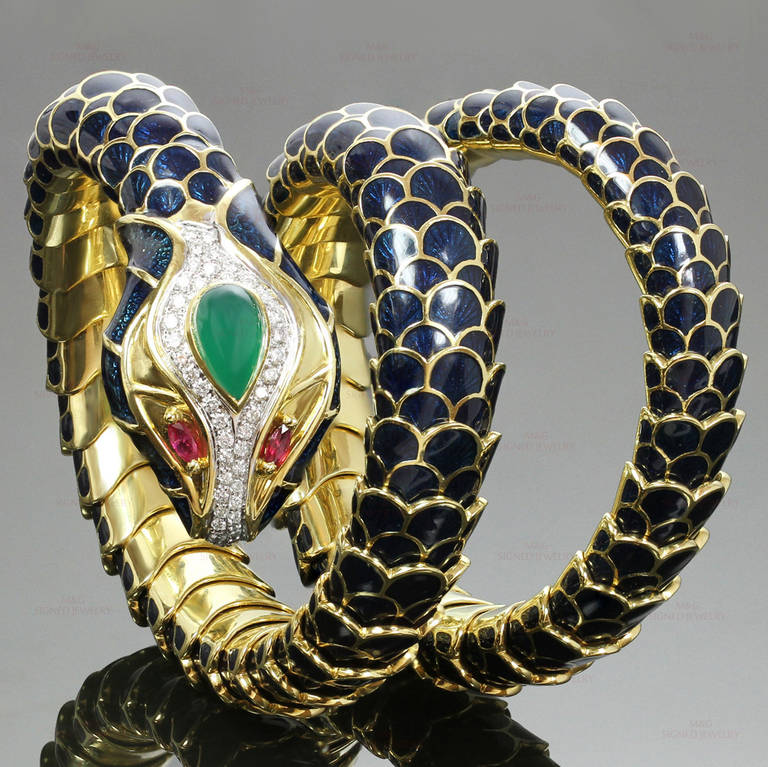 This gorgeous Roberto Legnazzi bracelet is designed as a flexible coiled snake with dark blue enamel scales, accented with pear-cut faceted ruby eyes, a pave-set diamond head (an estimated 1 carat of 28 F-G VS1-VS2 round diamonds), centering a