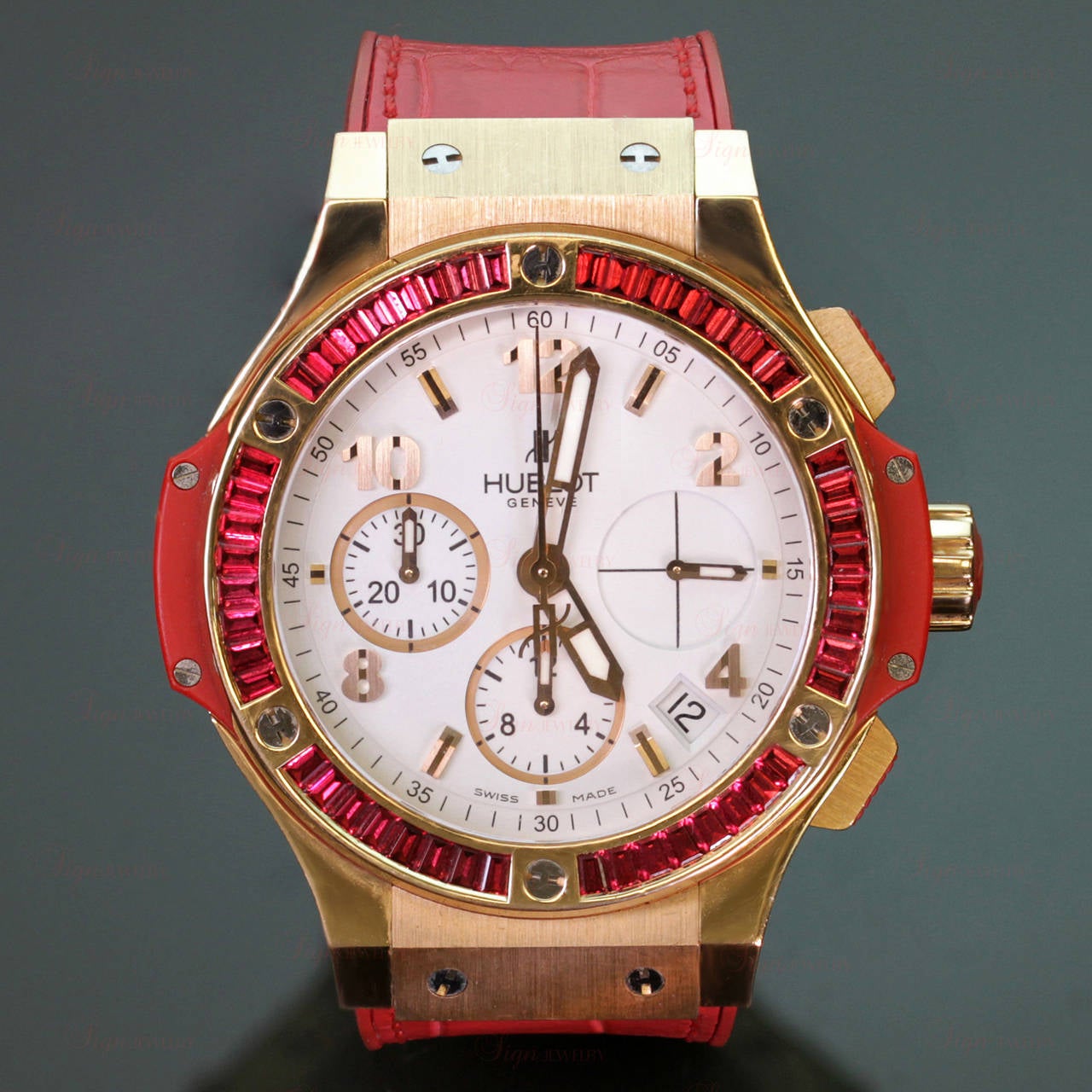 This fabulous 38mm Hublot's Big Bang Tutti Frutti HUB 2900 wristwatch features an 18k yellow gold circular bezel with 48 channel-set baguette-cut red spinels, a tonneau case with red lateral composite resin inserts, a white dial with applied Arabic