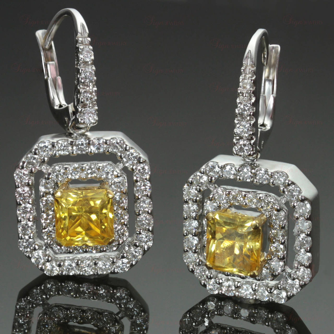 This pair of striking classic earrings features 3 carats natural intense yellow sapphires set in yellow gold with 2.12 carats of VS diamonds set in 18k white gold. Measurements: 0.47" (12mm) width, 1.02" (26mm) length.