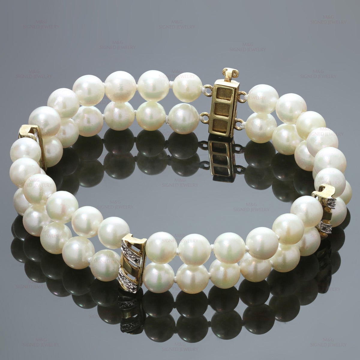 This modern bracelet features two strands of 6.0mm - 6.5mm cultured pearls accented with 14k yellow gold dividers and clasp set with round diamonds of an estimated 0.12 carats. Measurements: 0.47