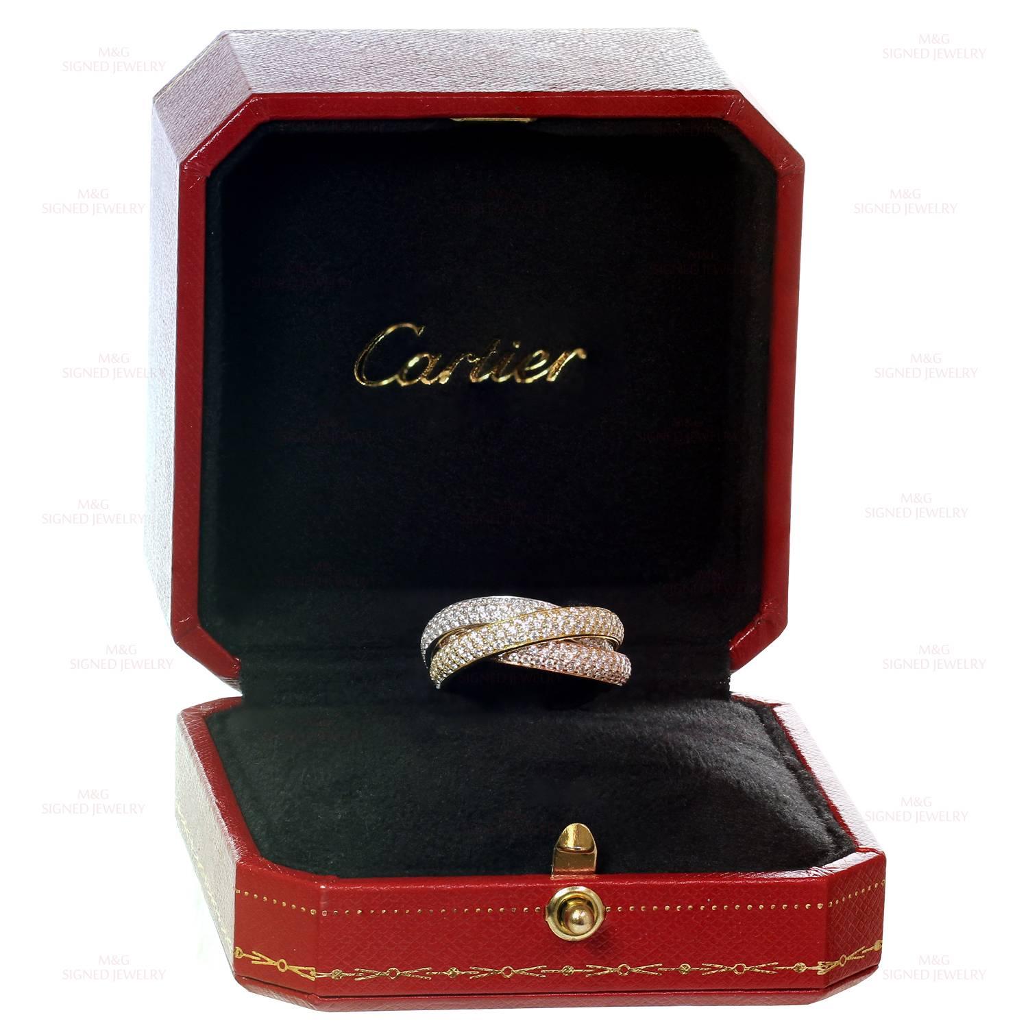 This iconic ring from Cartier's Trinity collection features 3 interconnected bands in 18k yellow, rose, and white gold, beautifully pave-set with sparkling brilliant-cut round diamonds of an estimated 3.0 carats. A classic and elegant design. Made