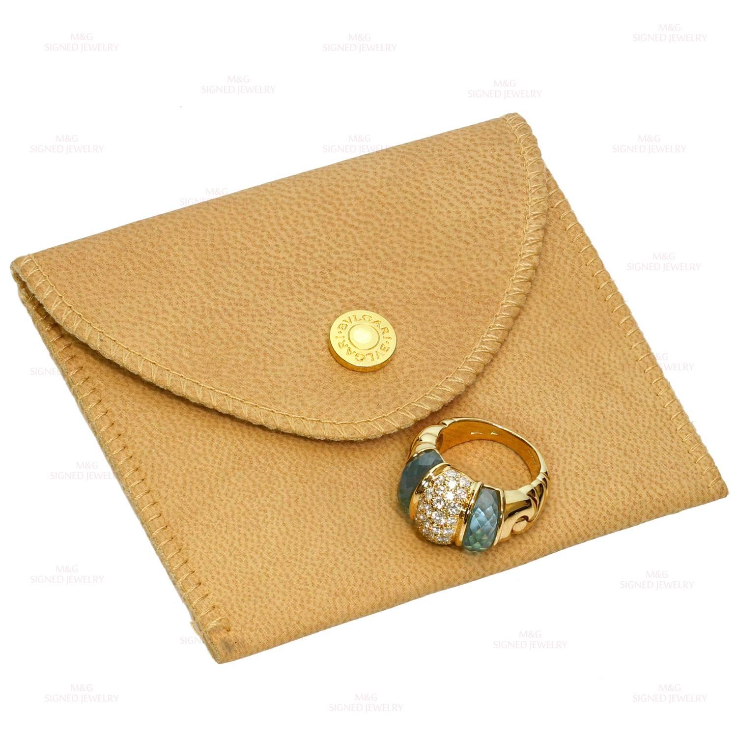 This chic Bulgari ring is crafted in 18k yellow gold and beautifully accented with faceted aquamarine side stones and a sparkling center of brilliant-cut round diamonds of an estimated 0.84 carats. Made in Italy. Measurements: 0.47" (12mm)