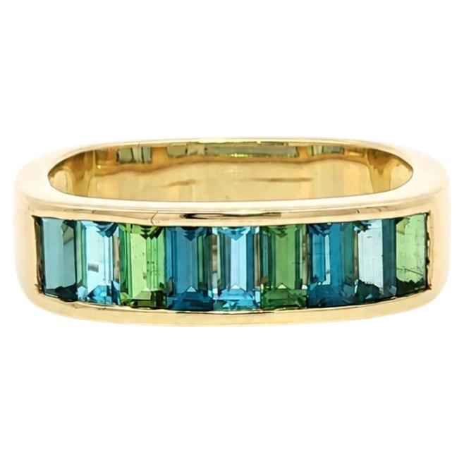 Anello con fascia quadrata in oro giallo 14k, con aquamarina e peridoto incastonati a baguette in canale