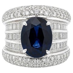 Anello in oro bianco 18 carati con zaffiro ovale certificato GIA da 4,9 carati totali e diamanti taglio baguette, con fascia larga a forma di sigaro