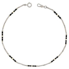 Catena da orologio d’epoca in stile Art Déco, con cilindro in oro e smalto bianco e nero e maglie ovali aperte
