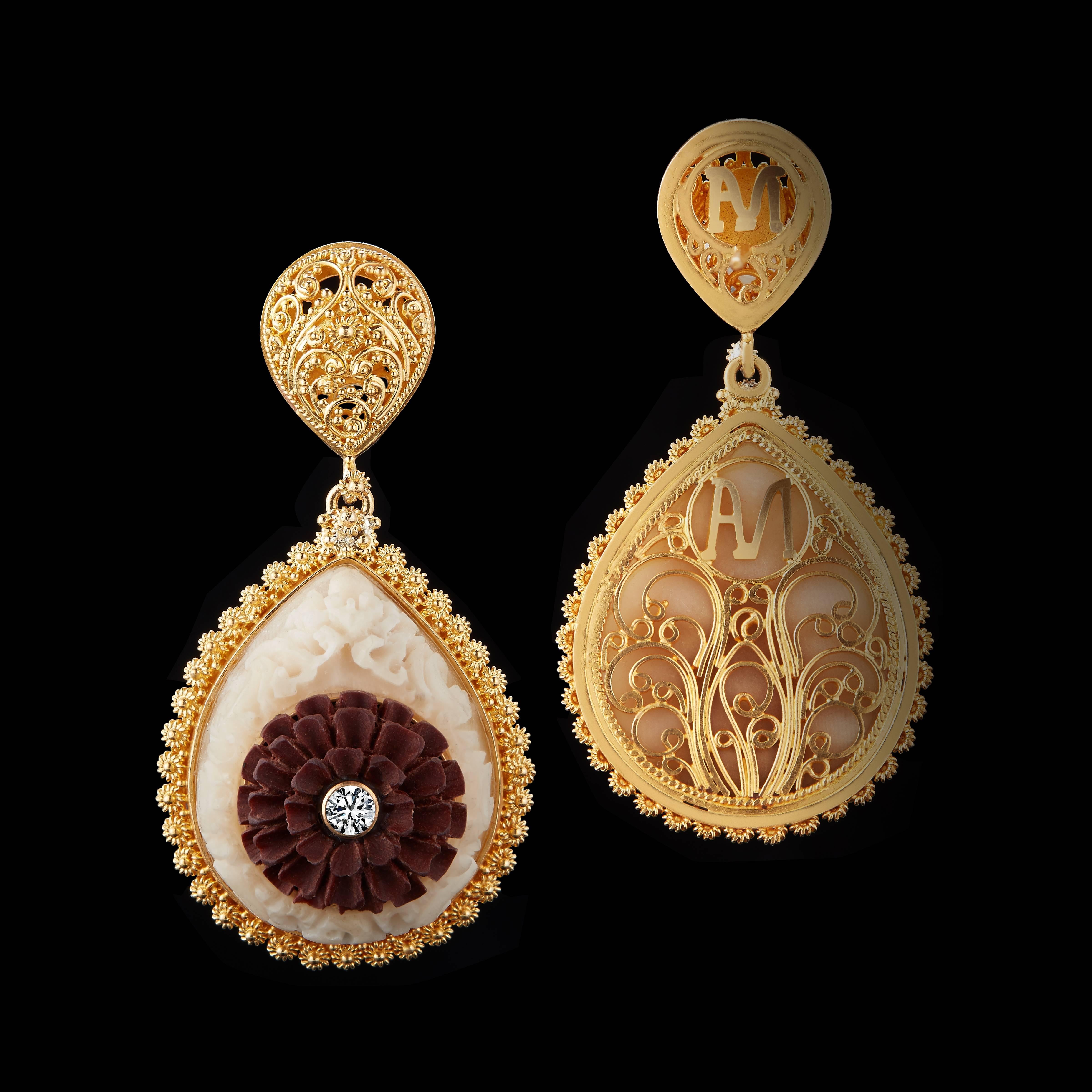 These teardrop earrings feature Balinese design motifs of the Kayonan, or Tree of Life, in carved Tagua and Lotus flowers in carved Sawo wood, accented by two Brilliant-cut Diamonds weighing .11 carats total. Prolific carvings in 22 karat yellow are