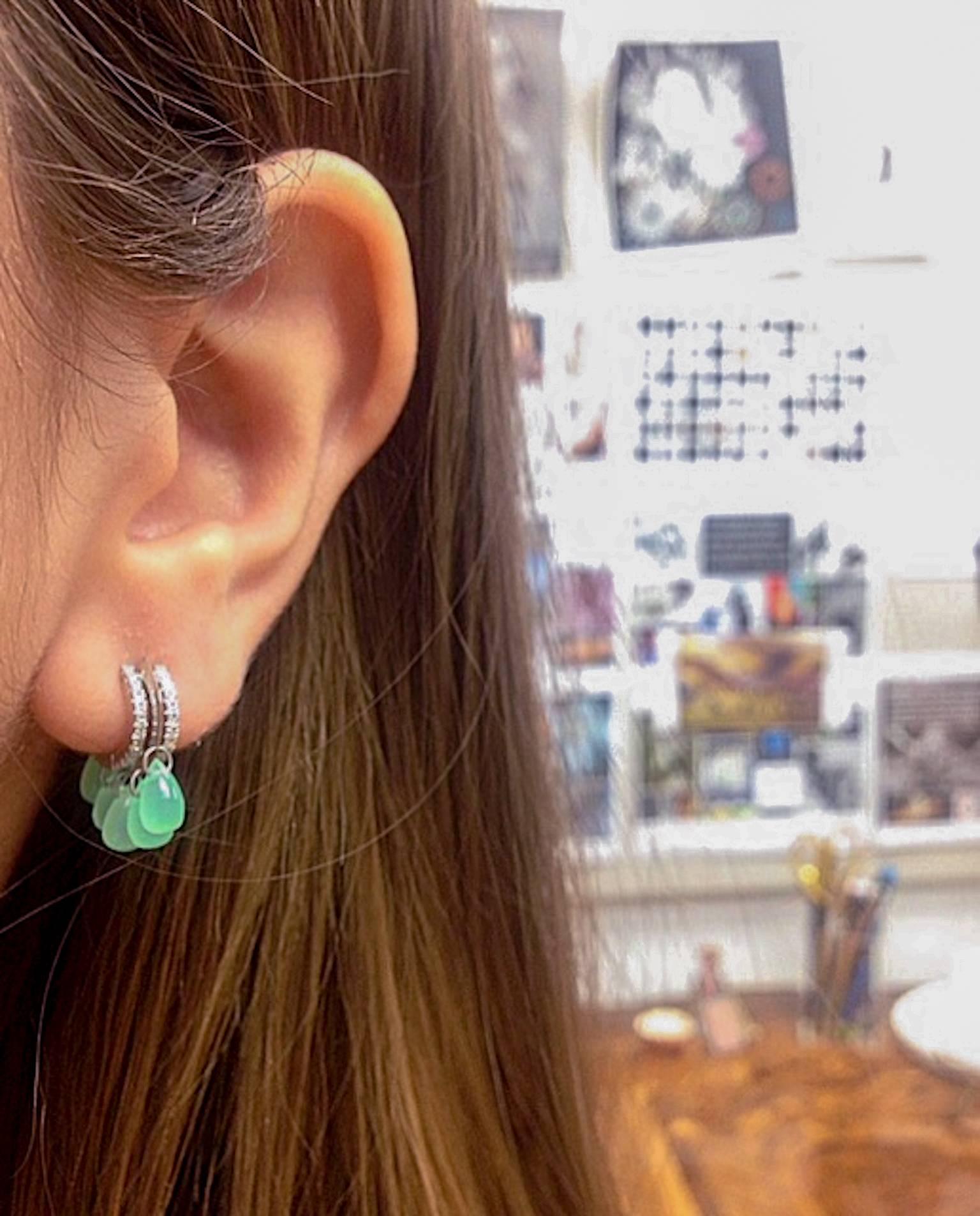 A pair of Alexandra Mor close-fitting Diamond hoop earrings featuring ten Green Chrysoprase Briolettes accented with Alexandra Mor's signature floating Diamond melee and knife-edged wire. Total Chrysoprase weight is 5.88 carats. Hoops feature 92
